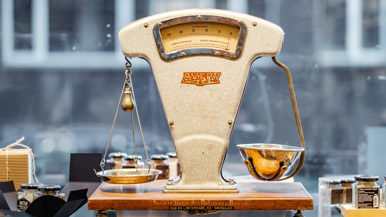 An Avery shop balance with a graduated dial and both pans empty, hanging at visibly different heights, doing the job this post describes: setting records that should agree side by side