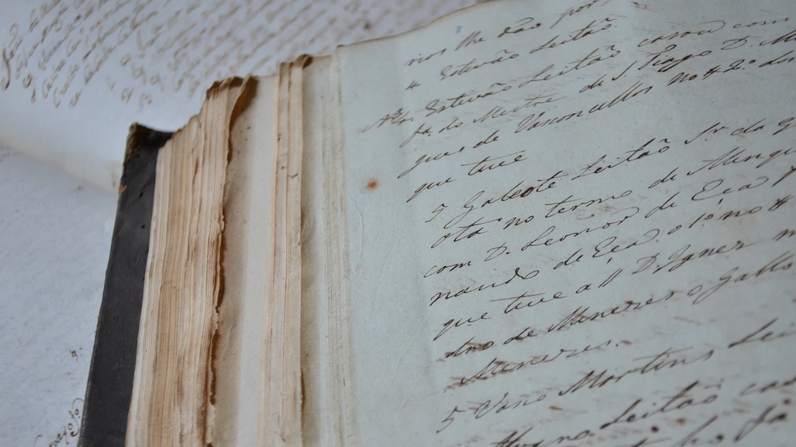 An old handwritten register lying open, its foxed pages closely written in ink — a record of what happened, kept apart from the thing it describes and reconciled with it by nobody